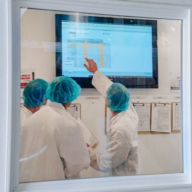 A team of technicians in a control room monitoring the performance data of an industrial spray dryer system, ensuring optimal efficiency for our industrial drying solutions.