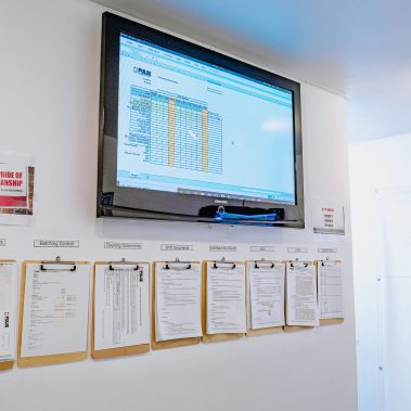 A quality control station showing a monitor with spray dryer system data and clipboards with batch control documentation, illustrating the meticulous process behind our industrial drying solutions.