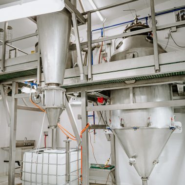 Industrial spray dryer system components, featuring large stainless steel tanks and hoppers, ready for efficient powder production and advanced drying system operations at http://pulsedry.com/.