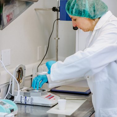 A lab technician meticulously analyzing a powder sample, ensuring the highest quality for products made with our advanced small spray dryer and industrial spray drying systems.