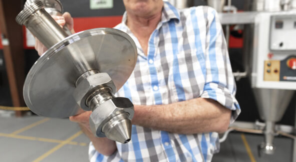 A close-up of a high-performance spray dryer atomizer, a critical component of our industrial spray drying equipment, held by an engineer.