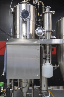 Detailed view of an industrial spray dryer system from Pulse Combustion Systems, showcasing the stainless steel construction and advanced spray drying equipment components.