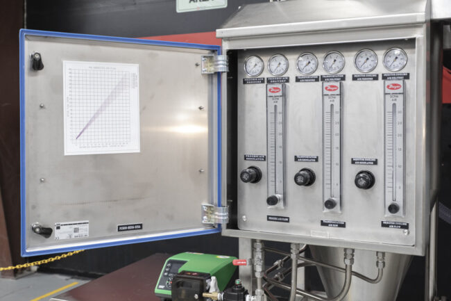 Control panel for an industrial spray dryer, showing precise airflow regulators and pressure gauges for the pulse combustion spray drying system.
