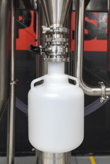 Powder collection container attached to the sanitary valve of an industrial spray dryer, part of a complete spray drying system by Pulsedry.com.