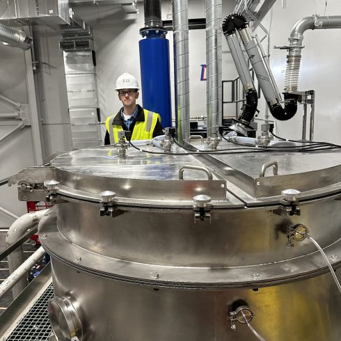 A Pulse.com engineer performing a quality inspection on a large-scale industrial spray dryer, a core component of our advanced spray drying systems.