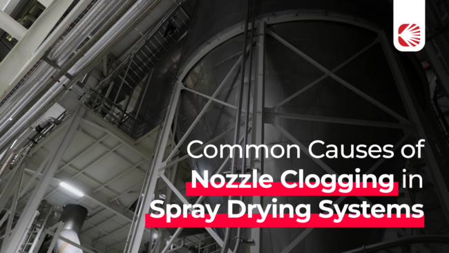 pulseDry_Blog_1-12 Banner with text for Common nozzle clogging in spray drying systems, with an industrial spray dryer on the background